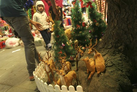 Người bán hàng đang trang trí lại bầy Tuần Lộc khi có khách đến mua.